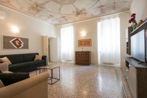 a living room filled with furniture and a tv at Piazza Paradiso Accommodation in Siena