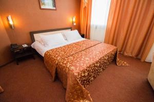 Habitación de hotel con cama grande con almohadas blancas en Barcelona Spa-Hotel, en Ulyanovsk