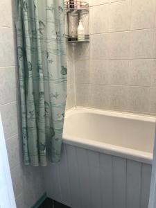 a bathroom with a tub and a shower curtain at Viru pst 20 in Sillamäe