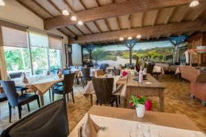 ein Restaurant mit Tischen und Stühlen und einem großen Fenster in der Unterkunft Logis Hôtels - Hôtel et Restaurant Les Voyageurs in Tournon-dʼAgenais