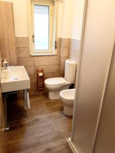 ein Bad mit einem WC und einem Waschbecken in der Unterkunft La casa dei sassi holiday house in Giardini-Naxos