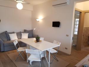 ein Wohnzimmer mit einem Tisch, Stühlen und einem Sofa in der Unterkunft La casa dei sassi holiday house in Giardini-Naxos