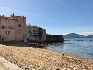 a group of buildings on a beach next to the water at Petit Jean in Saint-Tropez