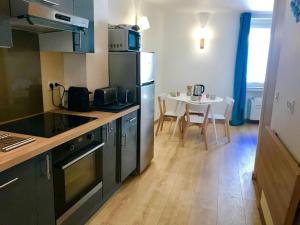 a kitchen with black appliances and a table with chairs at Petit Jean in Saint-Tropez +9 photos
