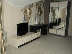 a living room with a tv on a dresser and a mirror at Hotel Leder in Kočani