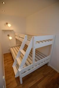 a white bunk bed in a room with wooden floors at Lägenhet centralt Lysekil in Lysekil
