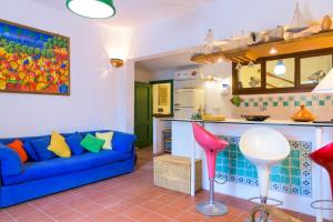 a living room with a blue couch and a kitchen at Villa Madreperla in Marciana
