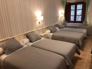 a row of beds in a room with lights at MONASTERIO de SANTA MARÍA DE VALVANERA in Anguiano