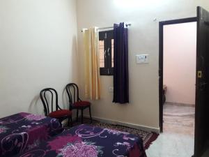a room with two chairs and a bed and a mirror at Mother Hostel in Varanasi