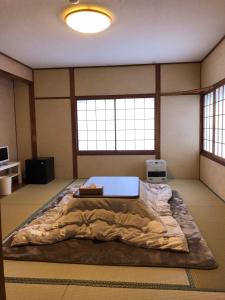 a large bed in a room with two windows at Oyado Zen in Kusatsu