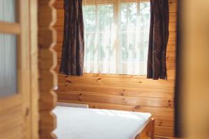 a bed in a room with a window at Pušynėlis in Miežonys