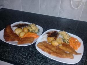 três pratos de comida num balcão preto em Jolani Guest House em Welkom