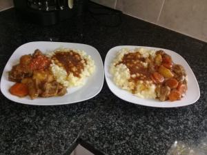 two plates of food with meat and potatoes on a counter at Jolani Guest House in Welkom