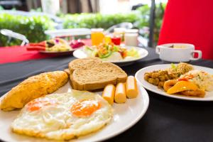 a table with plates of breakfast food on it at PJ Patong Resortel in Patong Beach