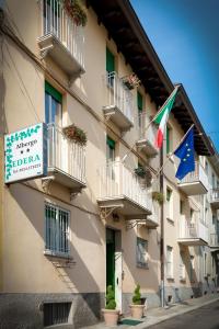 two flags are flying outside of a building at Albergo Edera in Salsomaggiore Terme