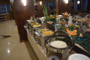 Serela Riau by KAGUM Hotels في باندونغ: طابور بوفيه مع اطباق طعام على طاولة