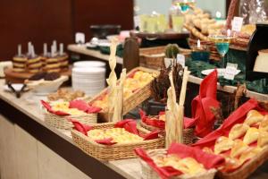 Serela Riau by KAGUM Hotels في باندونغ: بوفيه مع الكثير من سلال الطعام على طاولة