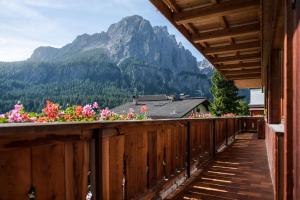 a balcony with flowers in front of a mountain at Residence Costa Burjada in Colfosco