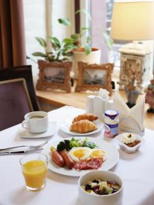 een tafel met borden ontbijtproducten en een kopje koffie bij Galunov Hotel in Sint-Petersburg