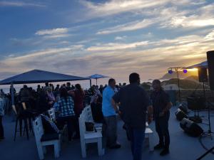 a group of people standing on a deck watching the sunset at Pili Pili Beach Cabanas in Sedgefield