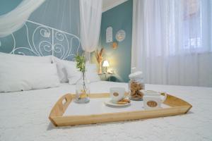 a tray with two cups and a tea set on a bed at Dida moj in Senj