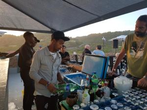a group of men standing around a table with drinks at Pili Pili Beach Cabanas in Sedgefield