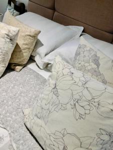 a bed with white sheets and pillows on it at Kwetu Cabin in Bordon