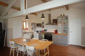 een keuken met een houten tafel en stoelen bij LE TEXIER The Cottage in Verteillac