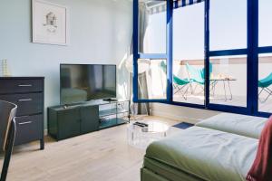 a living room with a couch and a flat screen tv at IKO Bordeaux Appartements in Bordeaux