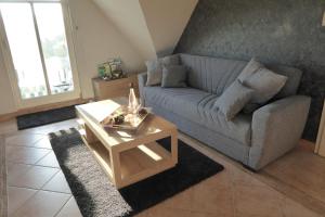 ein Wohnzimmer mit einem Sofa und einem Couchtisch in der Unterkunft Casa Carina Ferienhaus, Oberwohnung mit kleinem Sonnenbalkon und Terrasse in Süderschweiburg