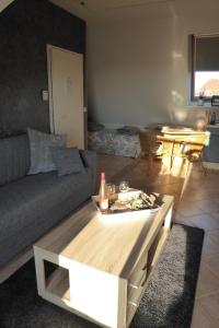 a living room with a couch and a table at Casa Carina Ferienhaus, Oberwohnung mit kleinem Sonnenbalkon und Terrasse in Süderschweiburg