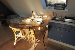 eine Küche mit einem Tisch, Stühlen und einem Waschbecken in der Unterkunft Casa Carina Ferienhaus, Oberwohnung mit kleinem Sonnenbalkon und Terrasse in Süderschweiburg