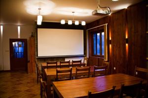 una sala de conferencias con mesas y sillas de madera y una pantalla en Chalet Balkan en Valevtsi