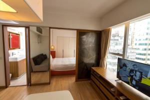uma sala de estar com televisão e um quarto em Homy Residence em Hong Kong
