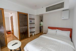 um quarto com uma cama branca e uma mesa em Homy Residence em Hong Kong mais 37 fotografias