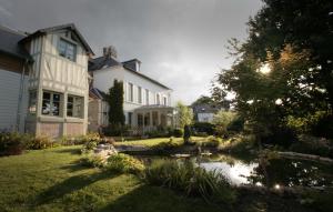 ein großes weißes Haus mit einem Teich im Hof in der Unterkunft Maison Saint Léonard in Honfleur