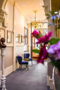 a waiting room with chairs and a chandelier at London Town Hotel in London