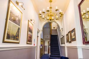 a hallway with a chandelier and paintings on the walls at London Town Hotel in London