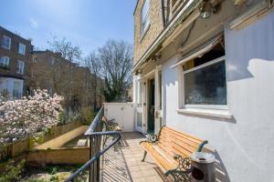 a wooden bench sitting on the porch of a house at London Town Hotel in London