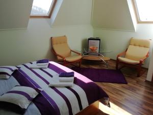 een slaapkamer met een bed en 2 stoelen en een tafel bij Casa Julia/Adult Only in Sovata