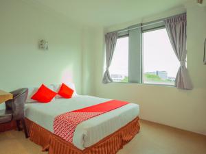 亞庇的住宿－Super OYO 218 Storytel，一间卧室配有一张带红色枕头的床和一扇窗户