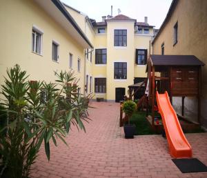 eine orangefarbene Rutsche im Innenhof eines Gebäudes in der Unterkunft Korzó Apartman in Kőszeg