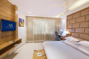 a hotel room with a large bed and a desk at Aura One Hotel in Cochin