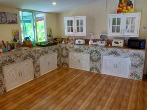 a kitchen with a counter top and a wooden floor at Private 2 bedroom villa with Swimming pool Tropical gardens Fast Wifi smart Tv in Ban Sang Luang