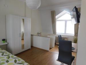 1 dormitorio con cama, escritorio y silla en Mona apartman, en Keszthely