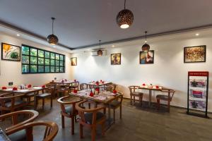 a restaurant with tables and chairs in a room at Aura One Hotel in Cochin