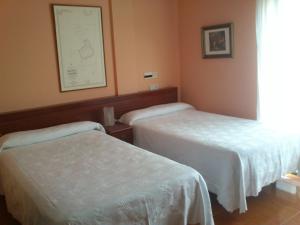 a hotel room with two beds and a picture on the wall at Hotel Brisamar in Bañugues