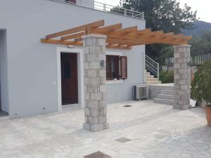 a house with a wooden pergola and a patio at Light blue house 1 in Poulithra