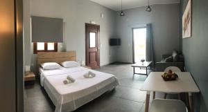 a bedroom with a large bed and a living room at Light blue house 1 in Poulithra