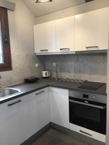 a kitchen with white cabinets and a black oven at Light blue house 1 in Poulithra